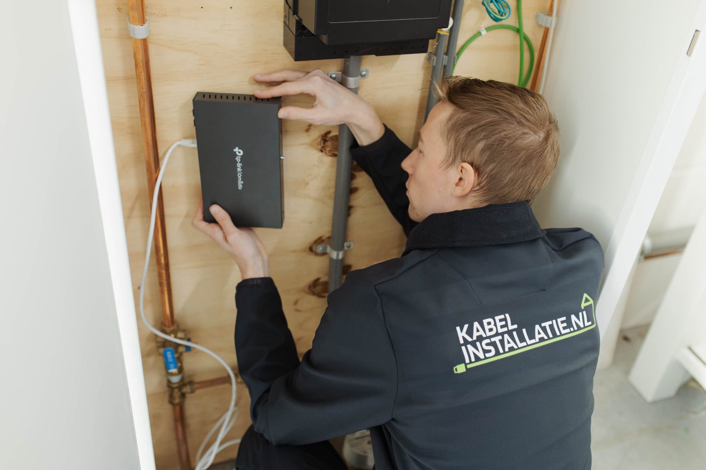 Monteur van Kabelinstallatie.nl sluit netwerkapparatuur aan